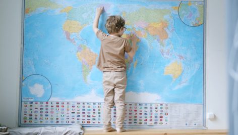 World map on the wall and child