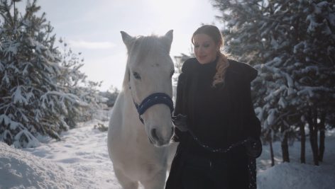 A girl with a horse in the snow